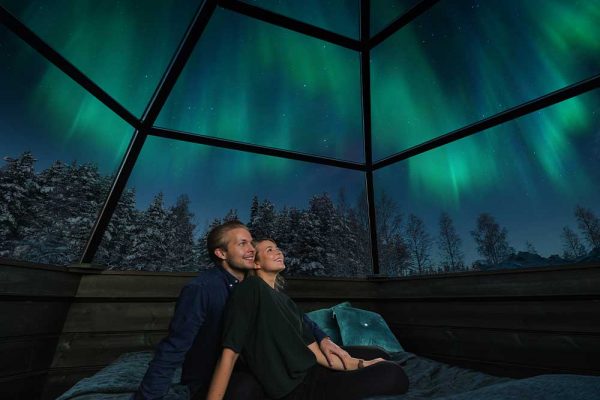 man and woman looking at northern lights